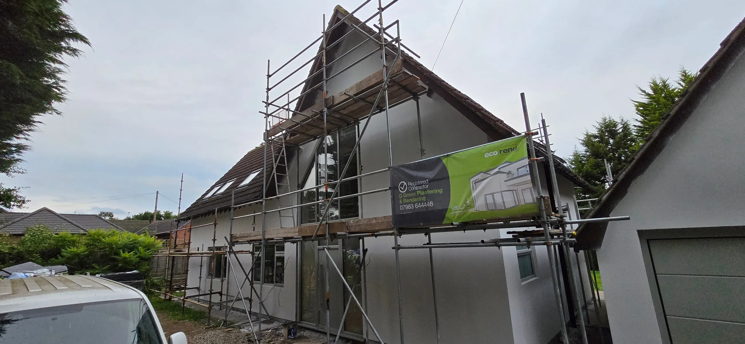 A property mid-conversion with external wall insulation boards fixed across it, ready to be rendered over.