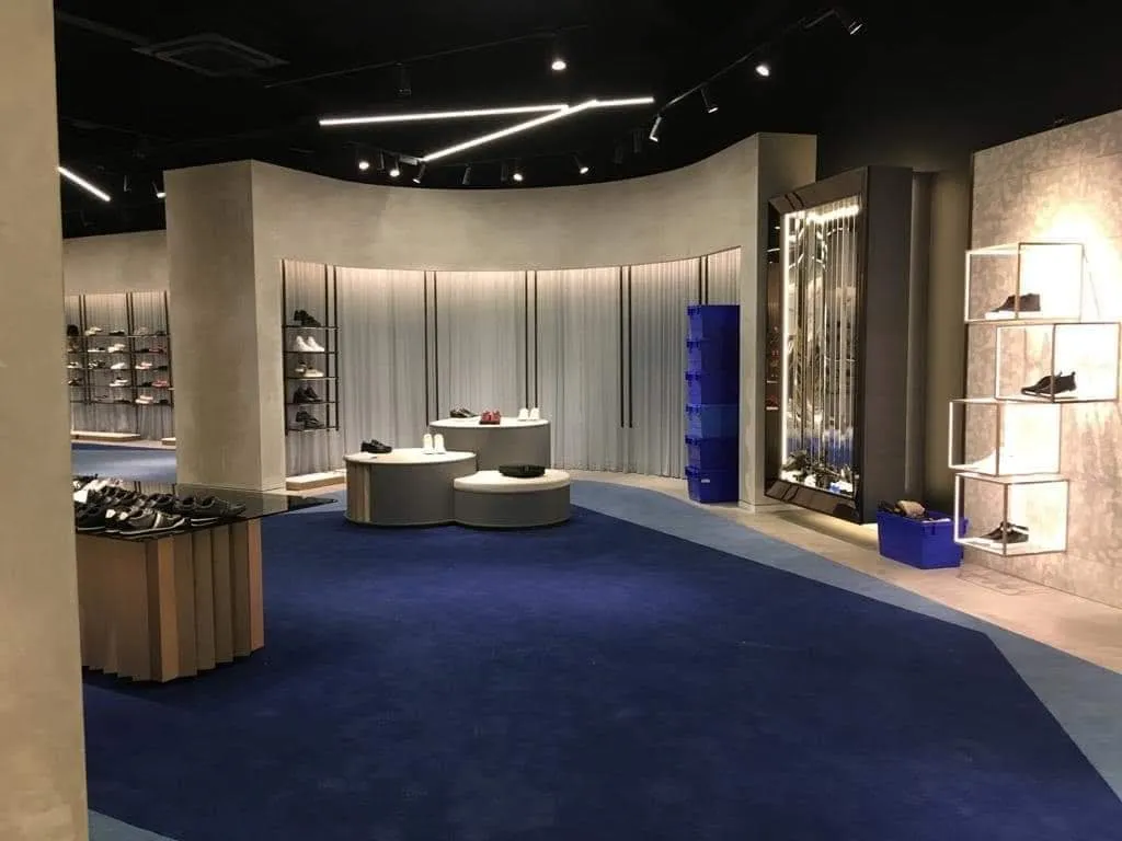 A retail shop interior with sweeping curved walls in a smooth plaster finish, lit by recessed strip lighting.