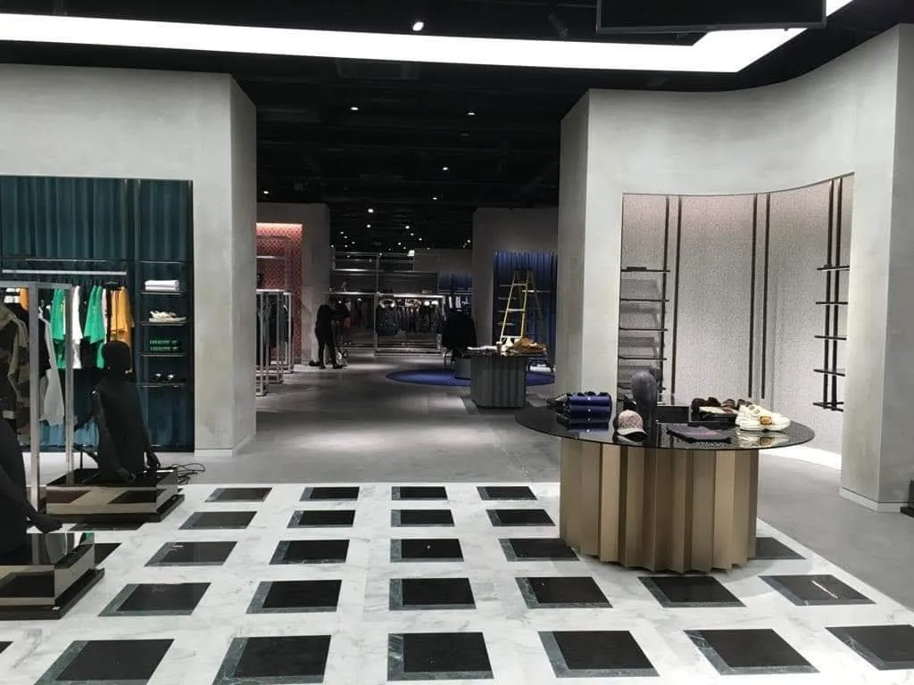 A wide view down a retail unit with plastered columns and walls running the length of the space.