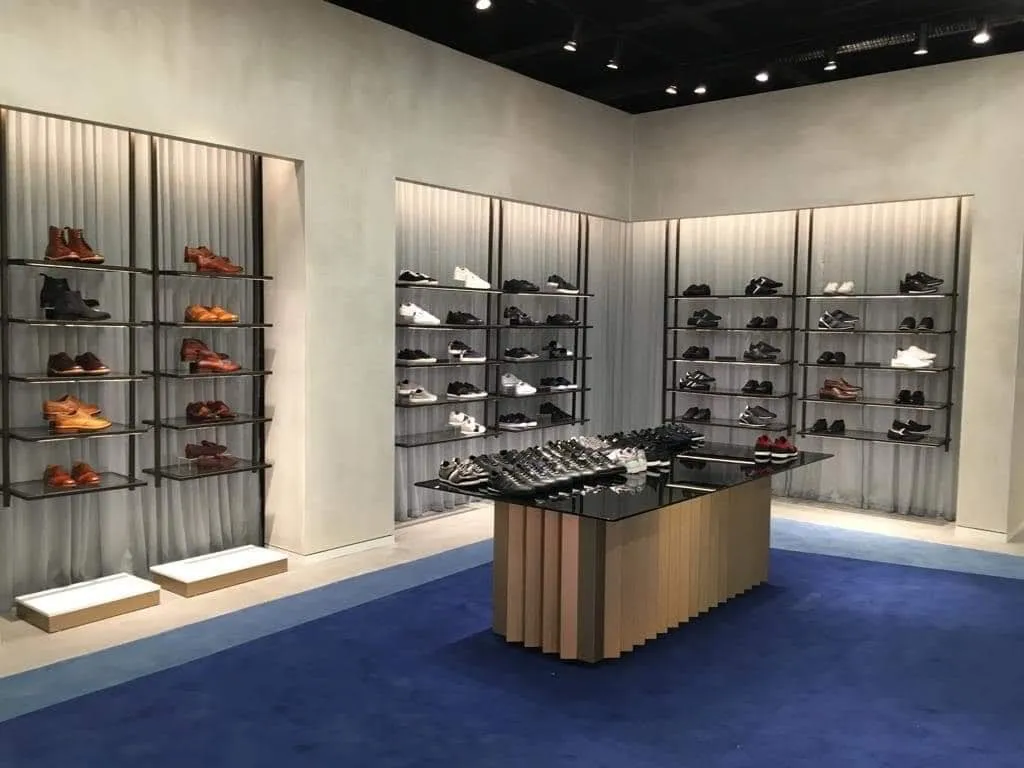 Shop interior with plastered display walls and integrated shelving lit from within.